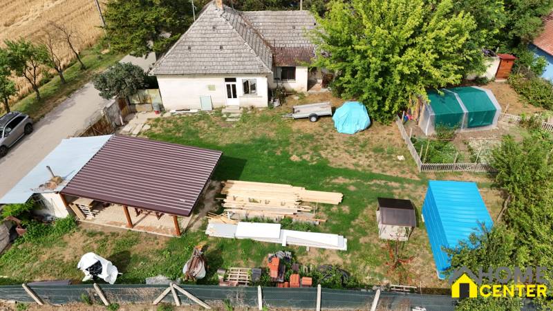 A family house in Kolárovo with a lawn, a shelter, a cart, and a vegetable garden.