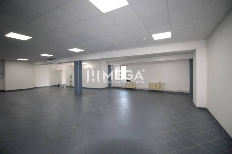 Spacious commercial premises with tiling and lighting, suitable for various uses.