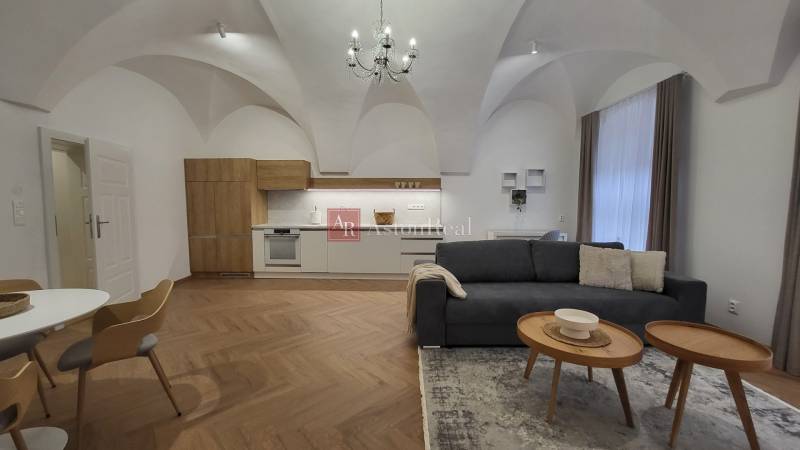 2-bedroom apartment with vaulted ceilings, a modern kitchen, and a comfortable living room with a chandelier.