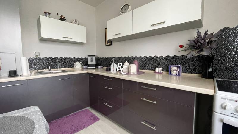 A kitchen with dark cabinets in a studio apartment.