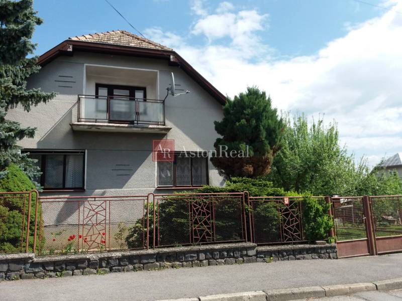 A family house in Banská Bystrica with a balcony, front garden, and fencing.