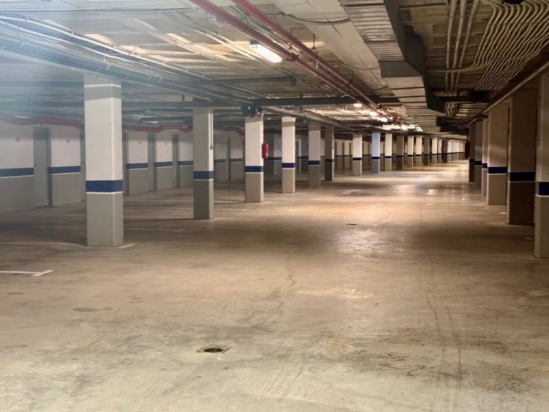 Underground parking with lighting and concrete pillars, recreational apartment.