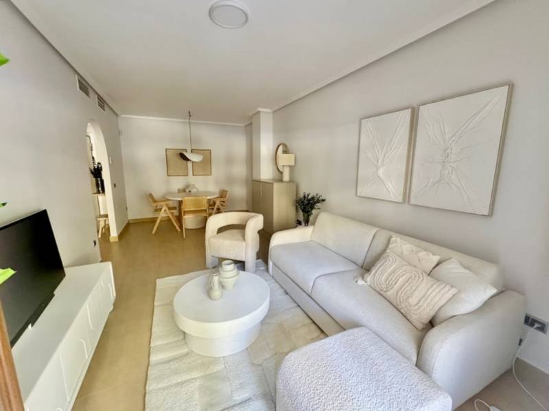 Living room of a holiday apartment with white furniture and decorations on the walls.