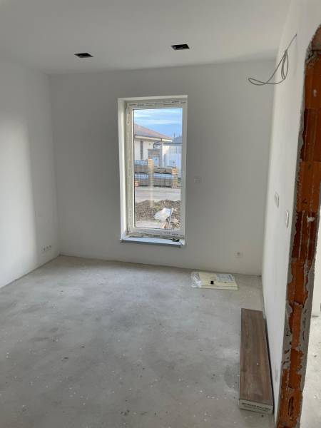 An empty room with white walls and a large window, House construction.