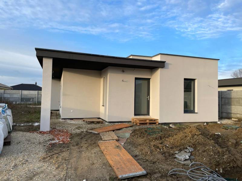 Construction of houses in Western Slovakia with a modern single-story house and unfinished landscaping.