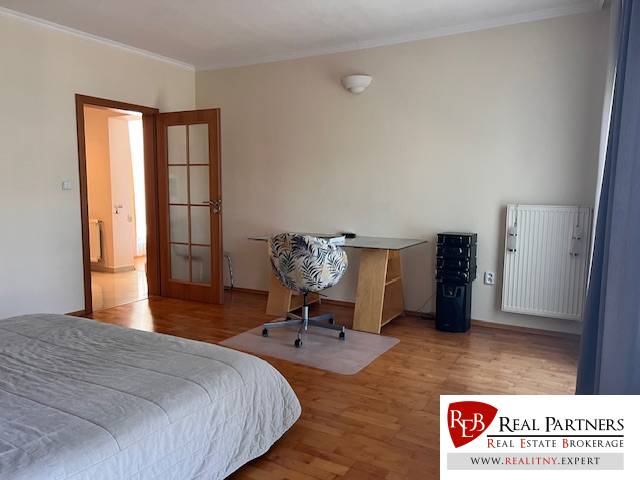 Bedroom in a 3-room apartment with a desk and wooden floor.