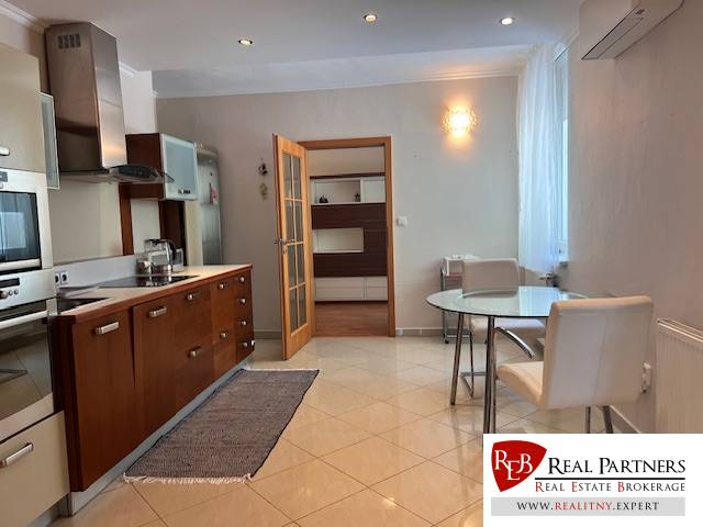 A kitchen with a dining table and chairs in a 3-room apartment.