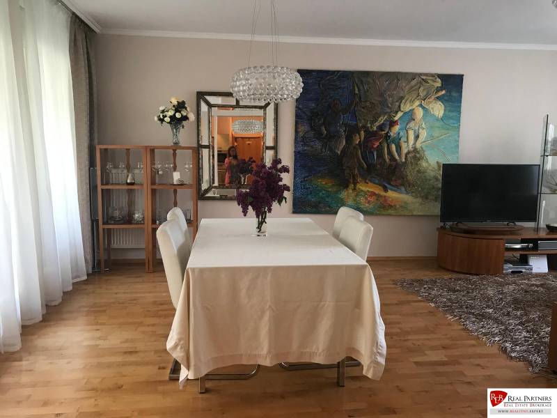 Dining room with a painting, a white table, and a shelf in a 3-room apartment.