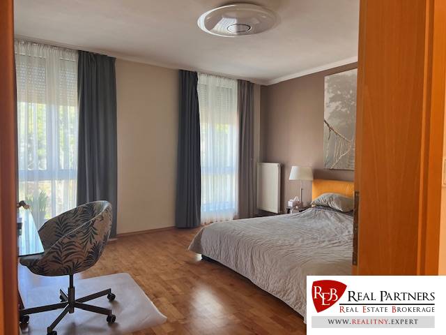 Bedroom in a 3-room apartment, bright room with a bed, chair, and large windows.