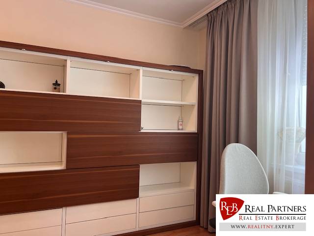 A shelving cabinet and curtains in a 3-room apartment with a bright interior.
