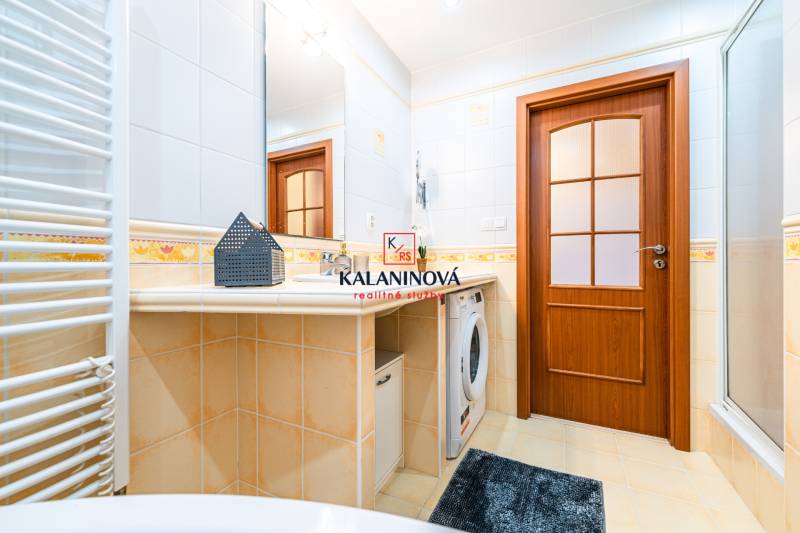 Bathroom in a 3-room apartment with wooden doors and a washing machine.