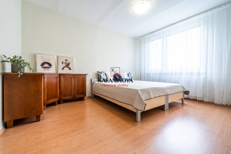 A bright bedroom with a wardrobe and a bed in a 3-room apartment.