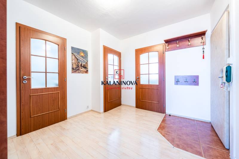 Entrance hall with wooden door and coat rack in a 3-room apartment.