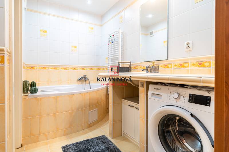 A bathroom with a bathtub, sink, and washing machine in a 3-room apartment.