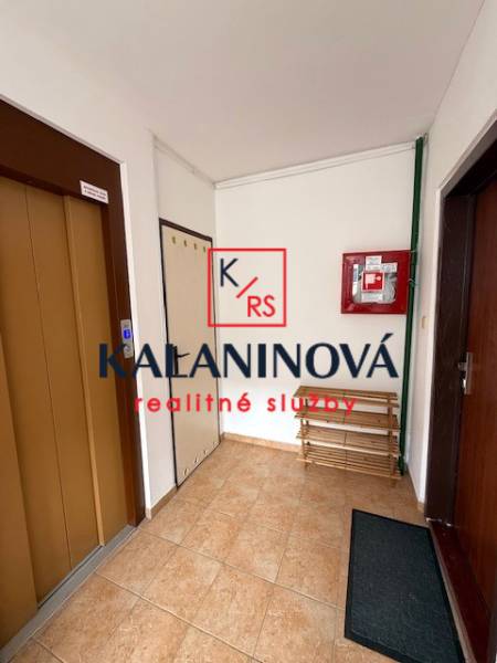 Entrance hall with an elevator and a bench in a 3-room apartment.