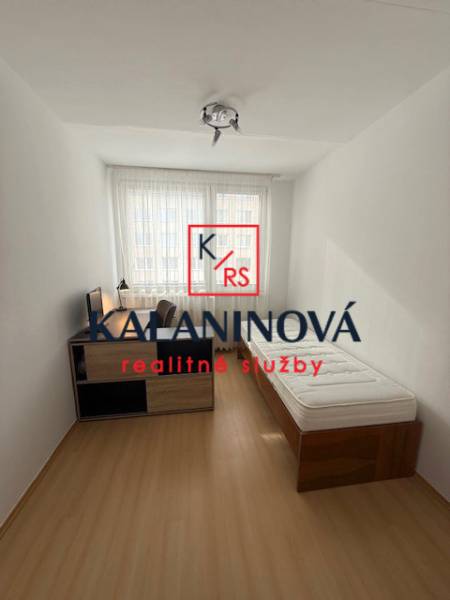 A bright room with a bed and a table in a 3-room apartment.
