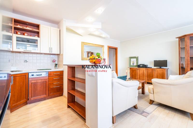 Living room in a 3-room apartment with a kitchen, wooden furniture, and a sofa set.