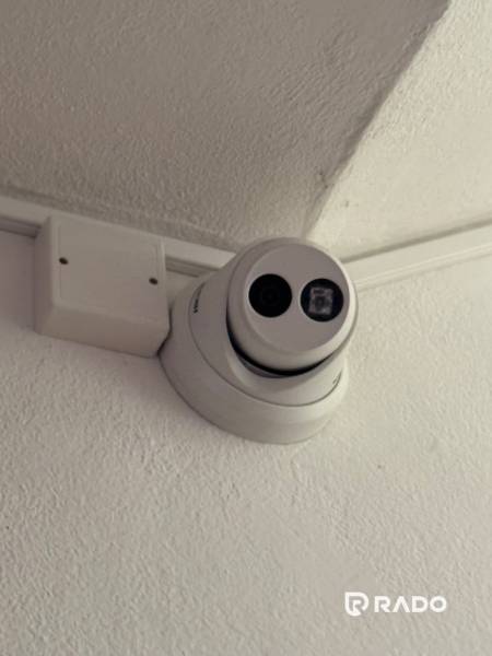 A security camera on the ceiling in a 3-room apartment, a recording device next to it.