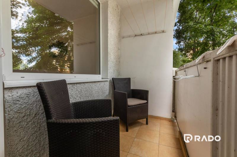 A balcony with two rattan chairs in a 3-room apartment.