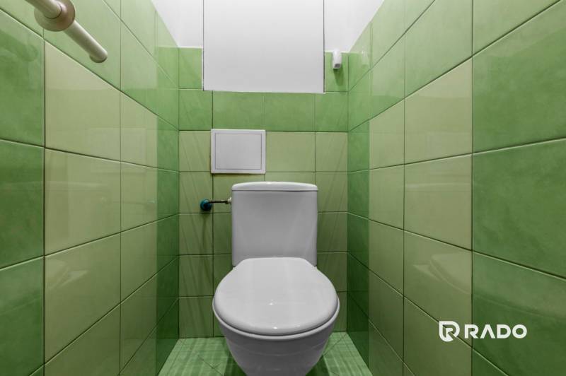 Bathroom in a 3-room apartment with green tiles and a toilet.