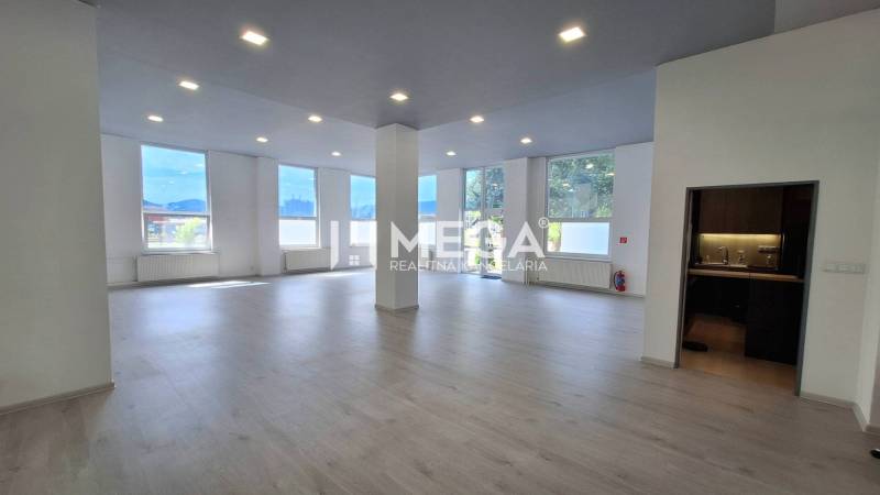 Spacious office spaces with large windows and wooden flooring.