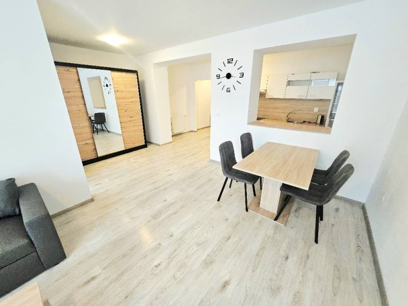 Living room with a dining table in a two-room apartment, bright interior and wooden floor.