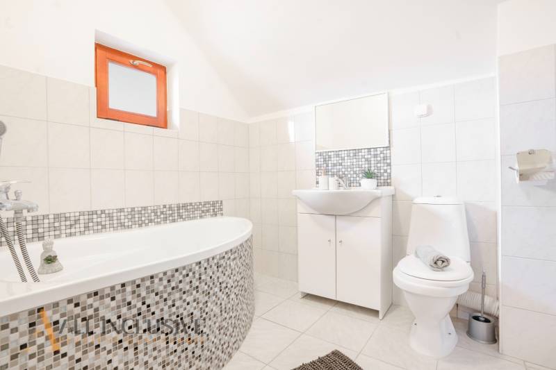 Bathroom with a bathtub and sink in hotels and guesthouses, bright tiles, minimalist style.