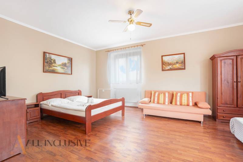 Interior of rooms in hotels and guesthouses with a wooden bed, sofa, and paintings.