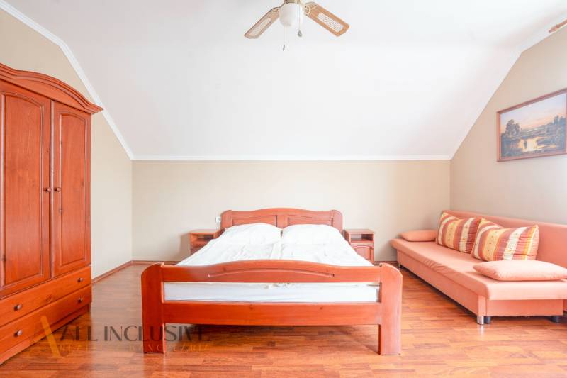 A bright room in hotels and guesthouses with wooden furniture and a sofa.