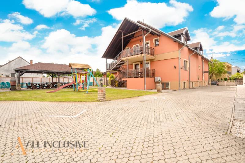 Exterior of hotels and guesthouses in Veľký Meder with a children's playground and a gazebo.