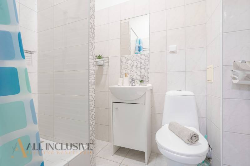 Bathroom with a shower, sink, and toilet, typical for hotels and guesthouses.