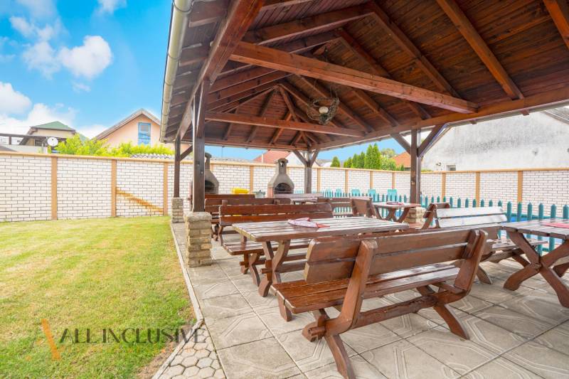 Garden in Hotels and Guesthouses in Veľký Meder with a gazebo and wooden seating.