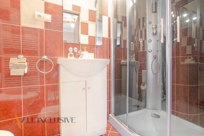 Bathrooms in hotels and guesthouses with red tiles and a shower enclosure.