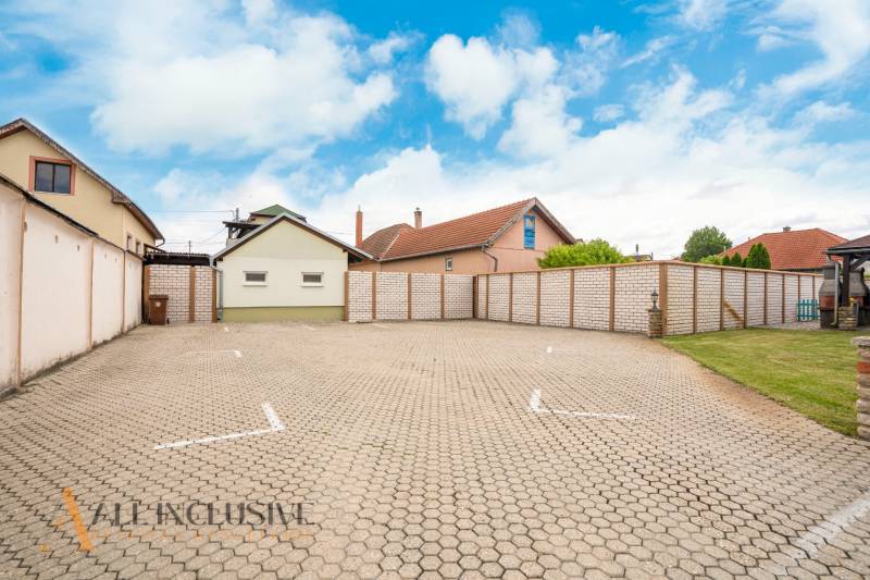 Parking at Hotels and Guesthouses in Veľký Meder with surrounding buildings and sky.