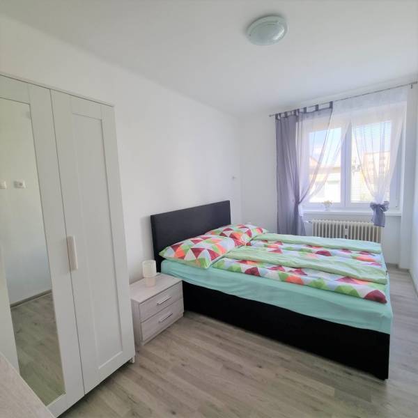 Bedroom in a 2-room apartment with a comfortable bed, wardrobe, and natural light.