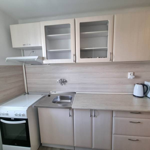 Kitchen in a 2-room apartment with a white unit, oven, and sink.