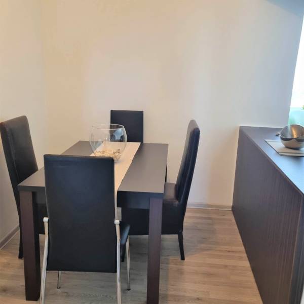 Dining area with a table and four chairs in a 2-room apartment.