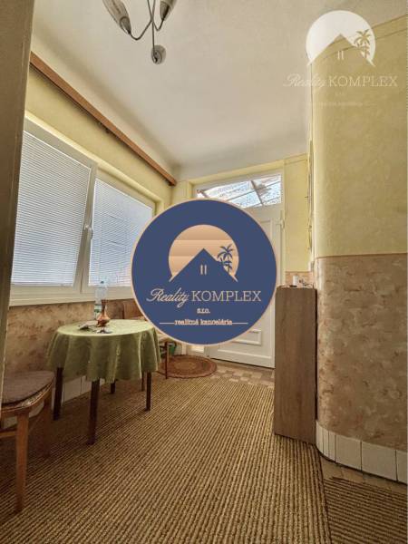 A hallway in a family house with a round table and a green tablecloth.