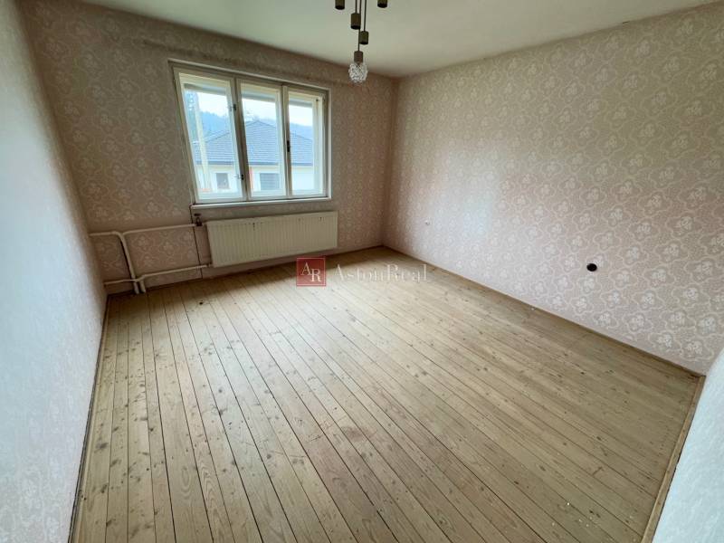 A room with a wooden floor in a 3-room apartment, Lietavská Lúčka, wallpapered walls.