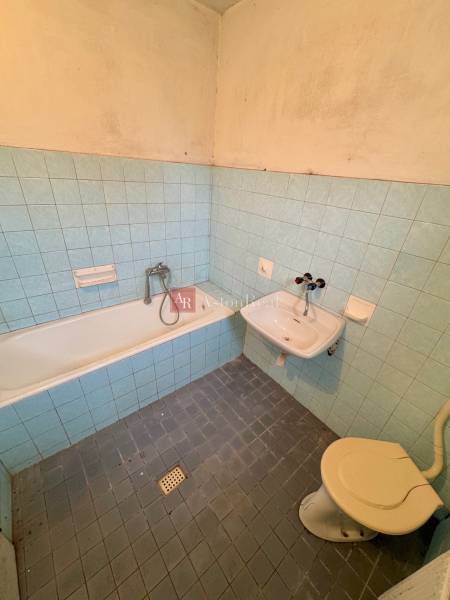 A classic bathroom with blue tiles, a bathtub, and a sink in a 3-room apartment.