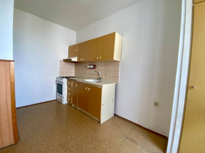 A kitchen in a 3-room apartment with a gas stove and cabinets.