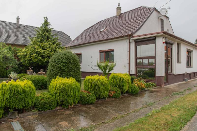 A family house in Rovinka surrounded by a landscaped garden with lush vegetation.
