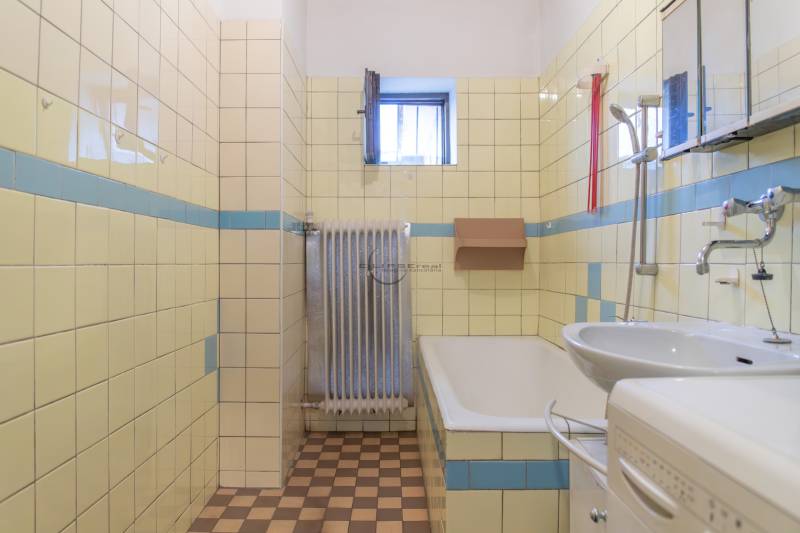 Bathroom in a family house with tiles and an older radiator.