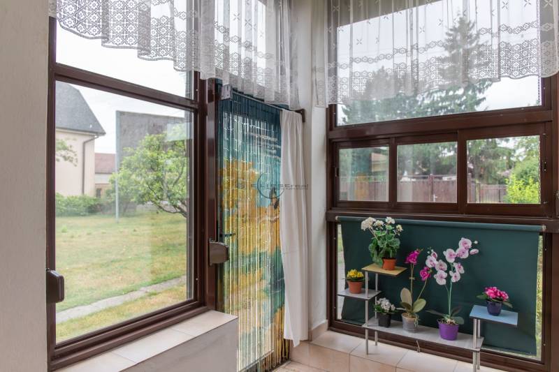 The interior of a family house with access to the yard, decorated with flowers on the windowsill.