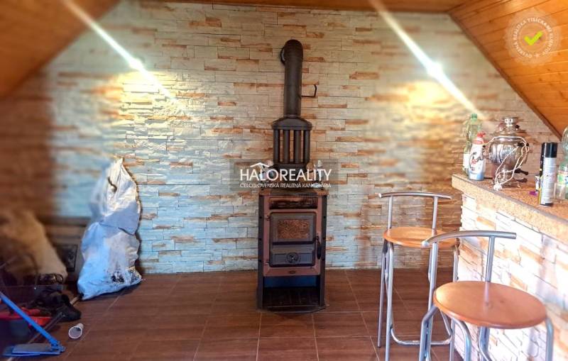 A cottage with a fireplace, wooden chairs, and a bar counter creates a cozy atmosphere.