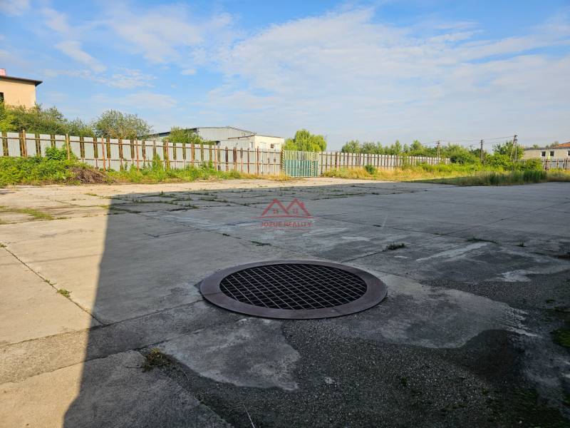 Concrete surface with a manhole cover in the area of Warehouses and Halls, Košice - Šaca district.