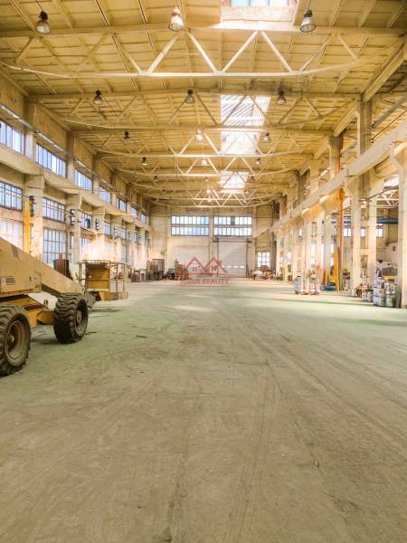 Spacious warehouses and halls with high ceilings and industrial lighting.