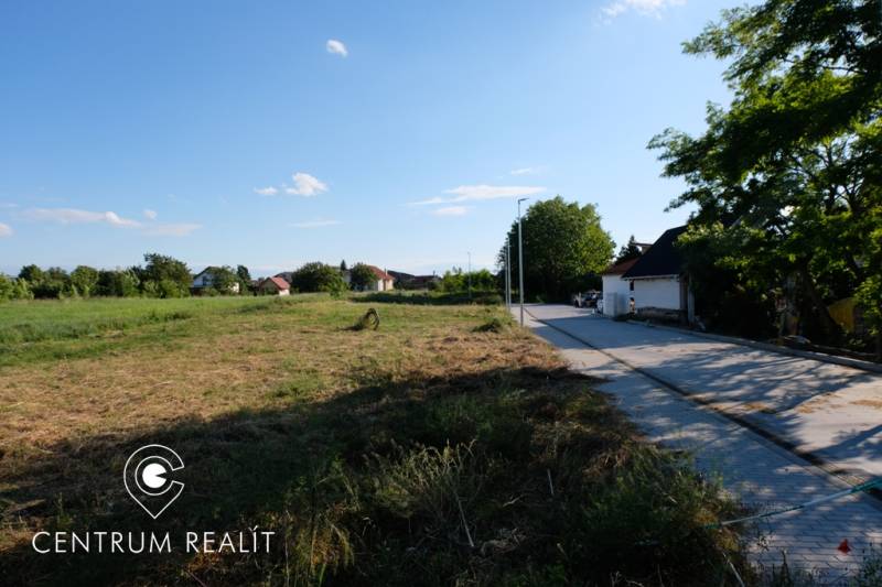 Plots - housing in Malinovo with a road next to the development and surrounding greenery.