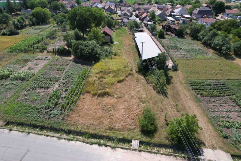 Landscape in Štrkovec with fields, buildings, and trees; natural parts of house construction.