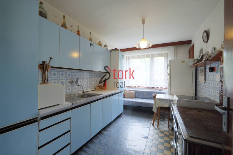 A kitchen with blue cabinets and patterned tiles in a family house.